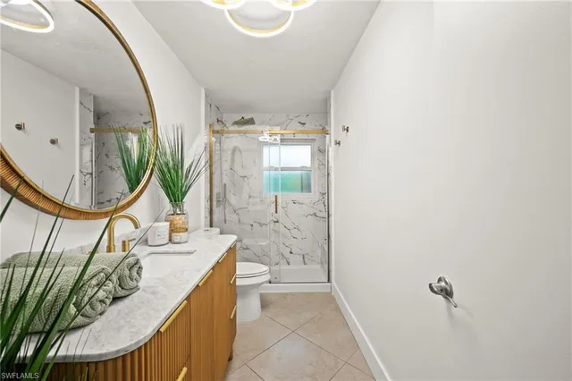 a bathroom with a granite countertop sink a mirror and shower