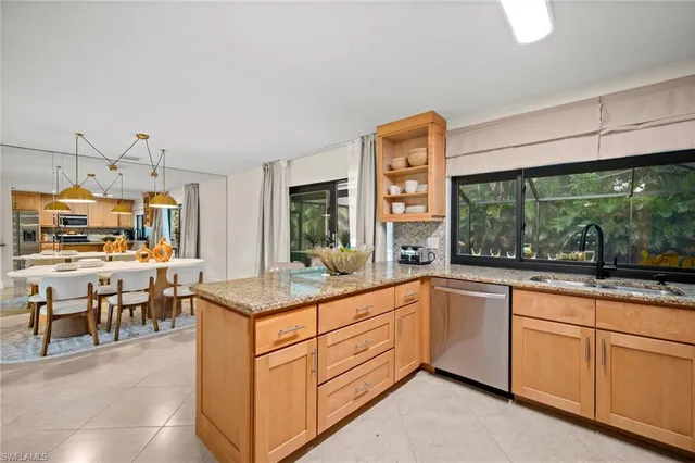 a open kitchen with granite countertop a sink and white cabinets