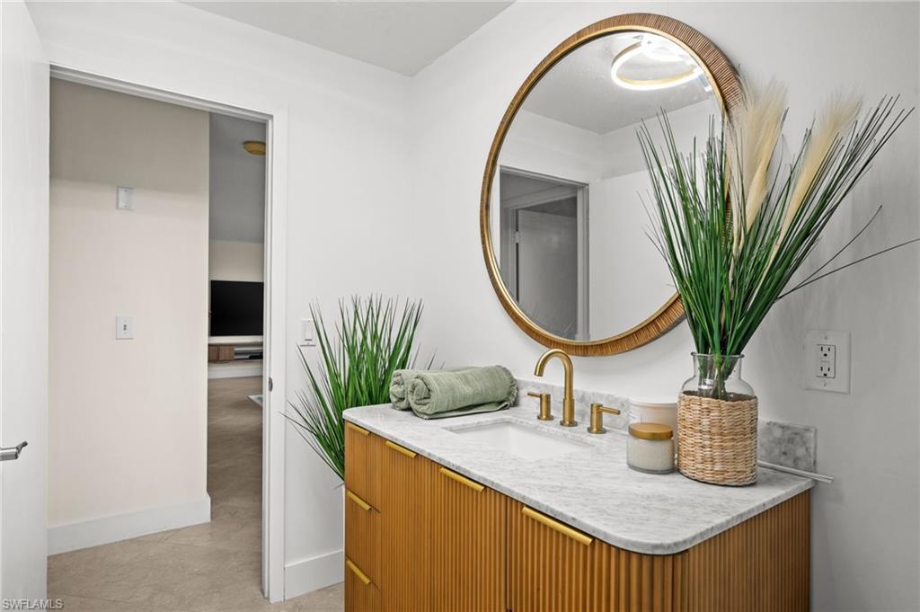 472 Palm River Boulevard Naples, FL 34110 - Photo 45 of 50 a bathroom with a sink a mirror and a potted plant