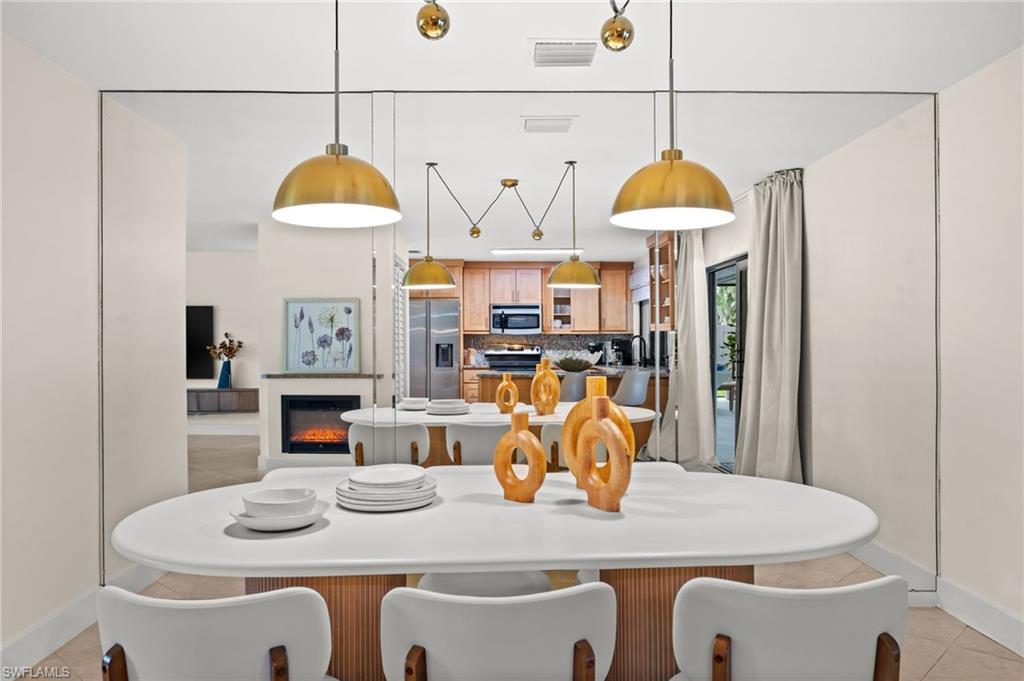 472 Palm River Boulevard Naples, FL 34110 - Photo 5 of 50 a dining room with furniture a window and kitchen view