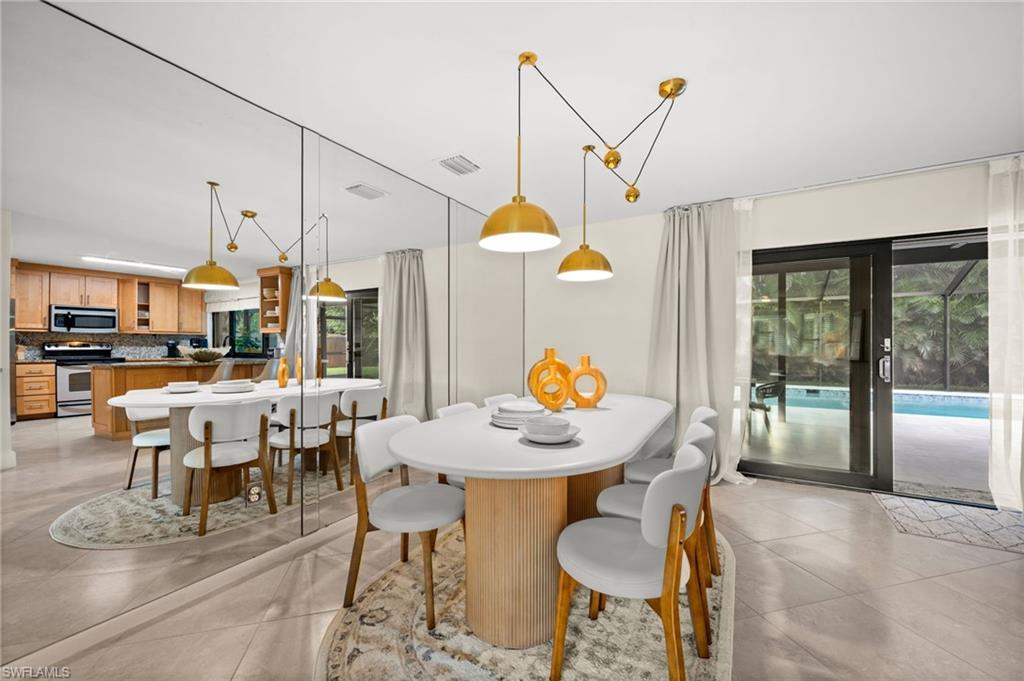 472 Palm River Boulevard Naples, FL 34110 - Photo 6 of 50 a dining room filled with furniture and a chandelier