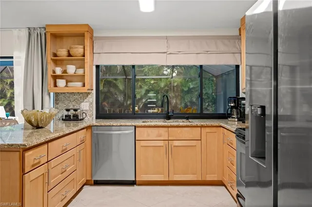 a kitchen with stainless steel appliances granite countertop a refrigerator and a sink