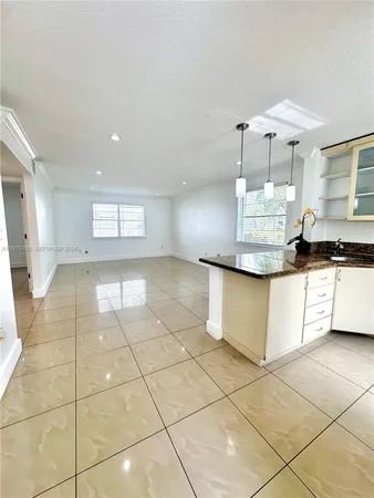 a large kitchen with granite countertop a stove a large mirror and a shower