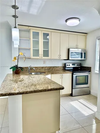 a kitchen with stainless steel appliances granite countertop a sink stove and cabinets