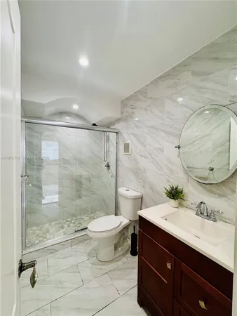 a bathroom with a double vanity sink toilet and shower