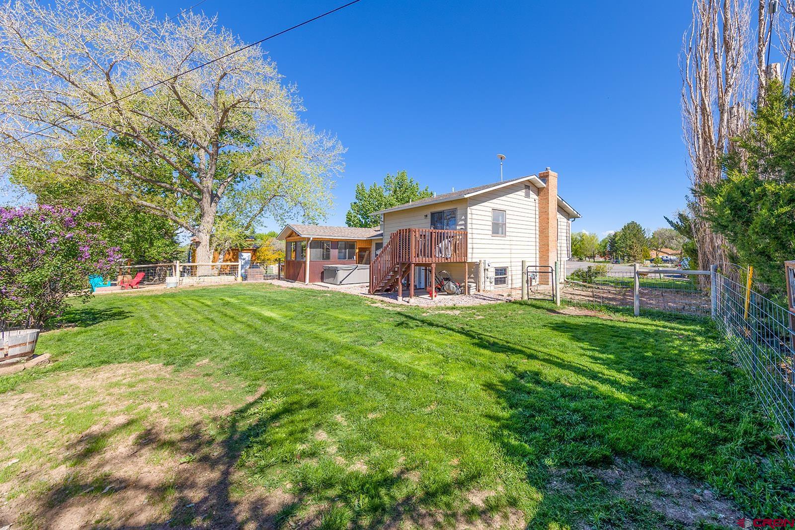 9467 6097 Road Montrose, CO 81401 - Photo 26 of 34 a view of a house with a yard deck and sitting area