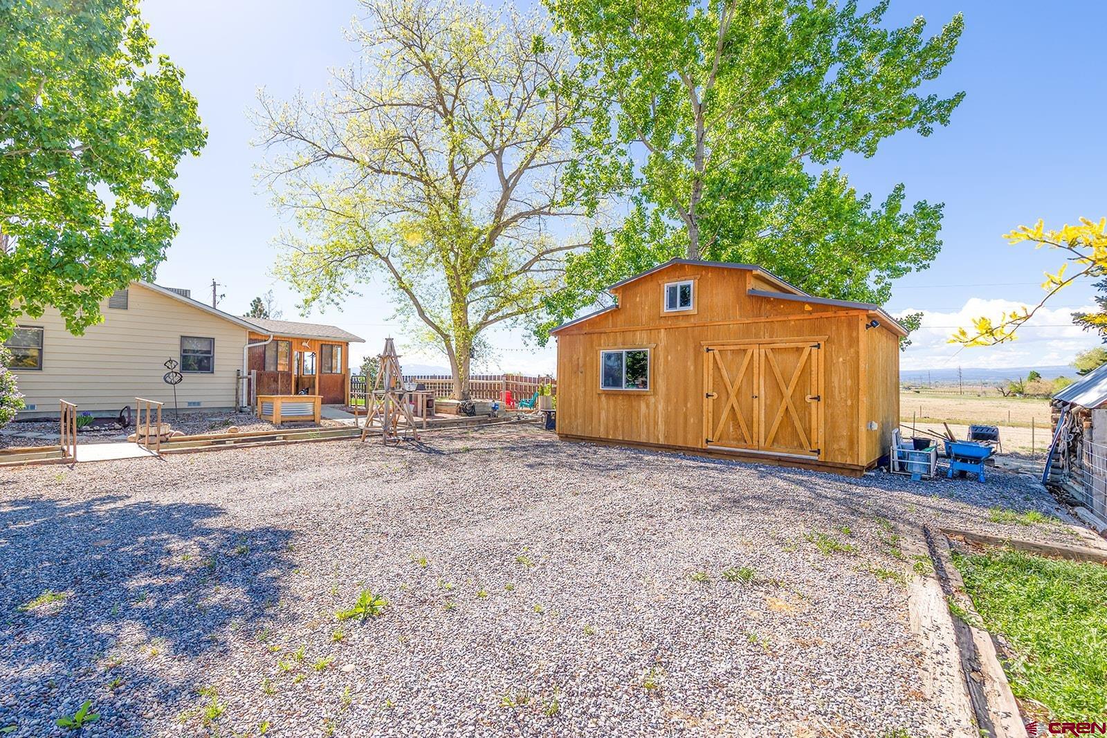 9467 6097 Road Montrose, CO 81401 - Photo 28 of 34 a front view of a house with a yard and garage