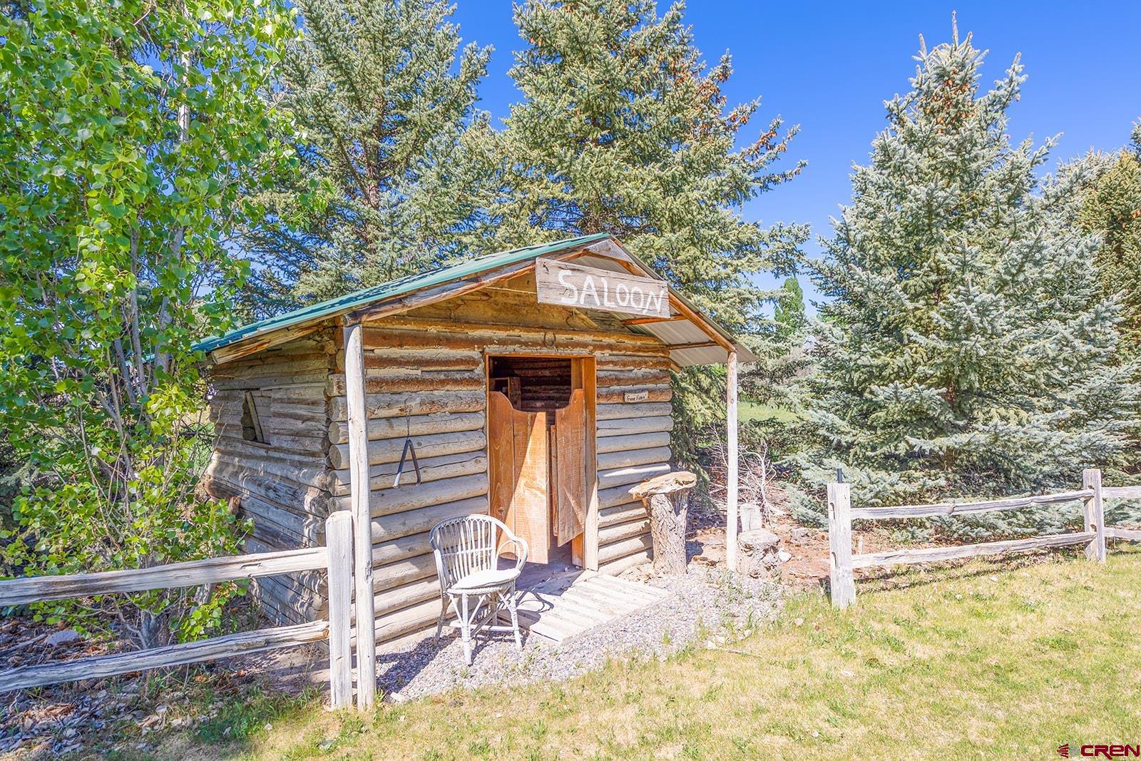 9467 6097 Road Montrose, CO 81401 - Photo 33 of 34 a backyard of a house with wooden fence and large trees