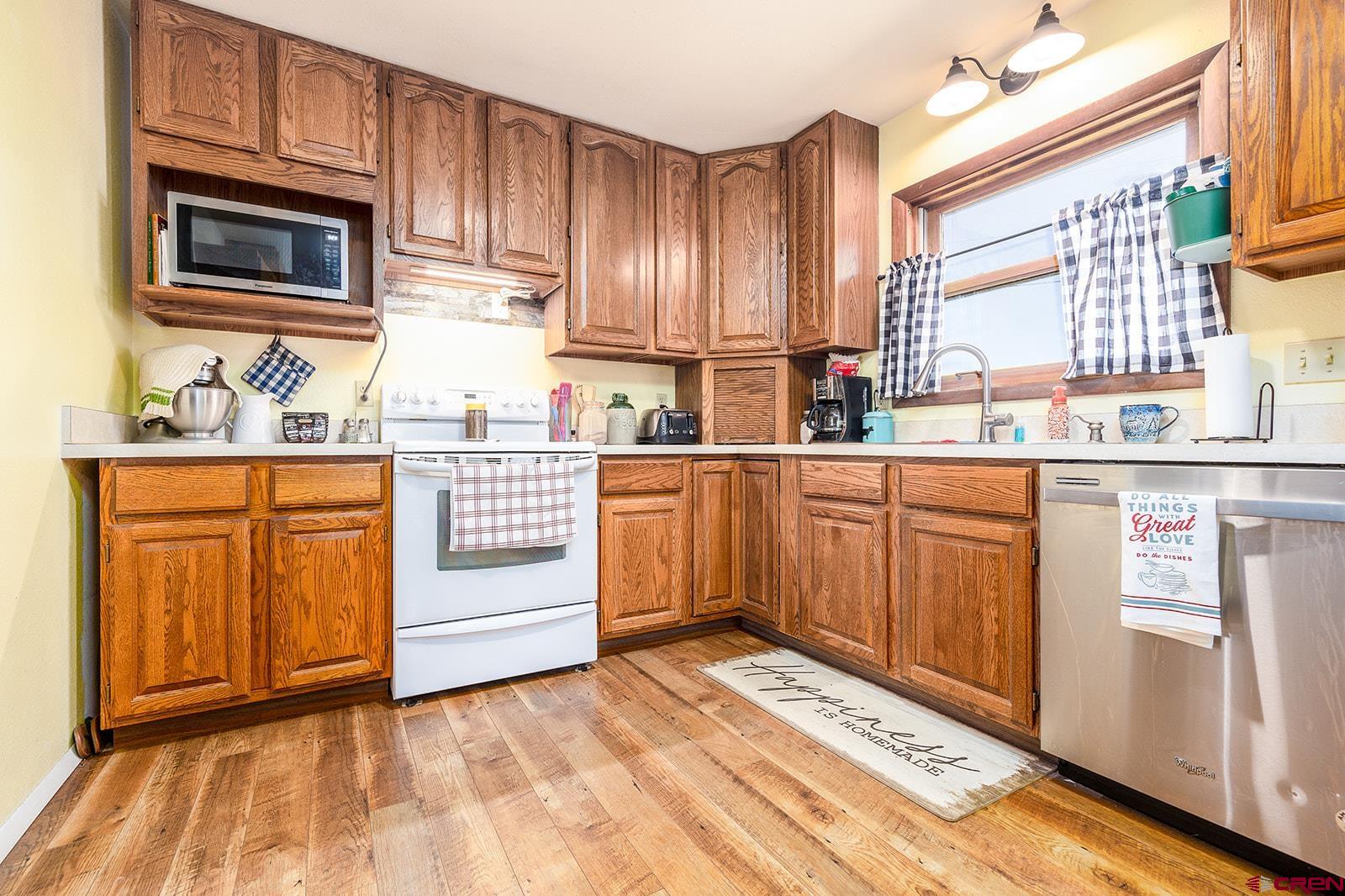 9467 6097 Road Montrose, CO 81401 - Photo 7 of 34 a kitchen with stainless steel appliances granite countertop a stove a sink and a microwave
