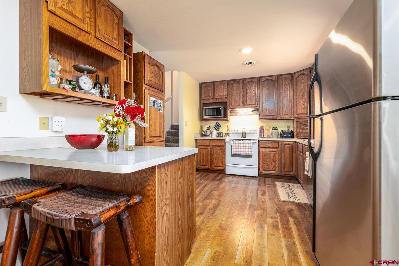 9467 6097 Road Montrose, CO 81401 - Photo 10 of 34 a kitchen with a refrigerator a stove a sink and cabinets