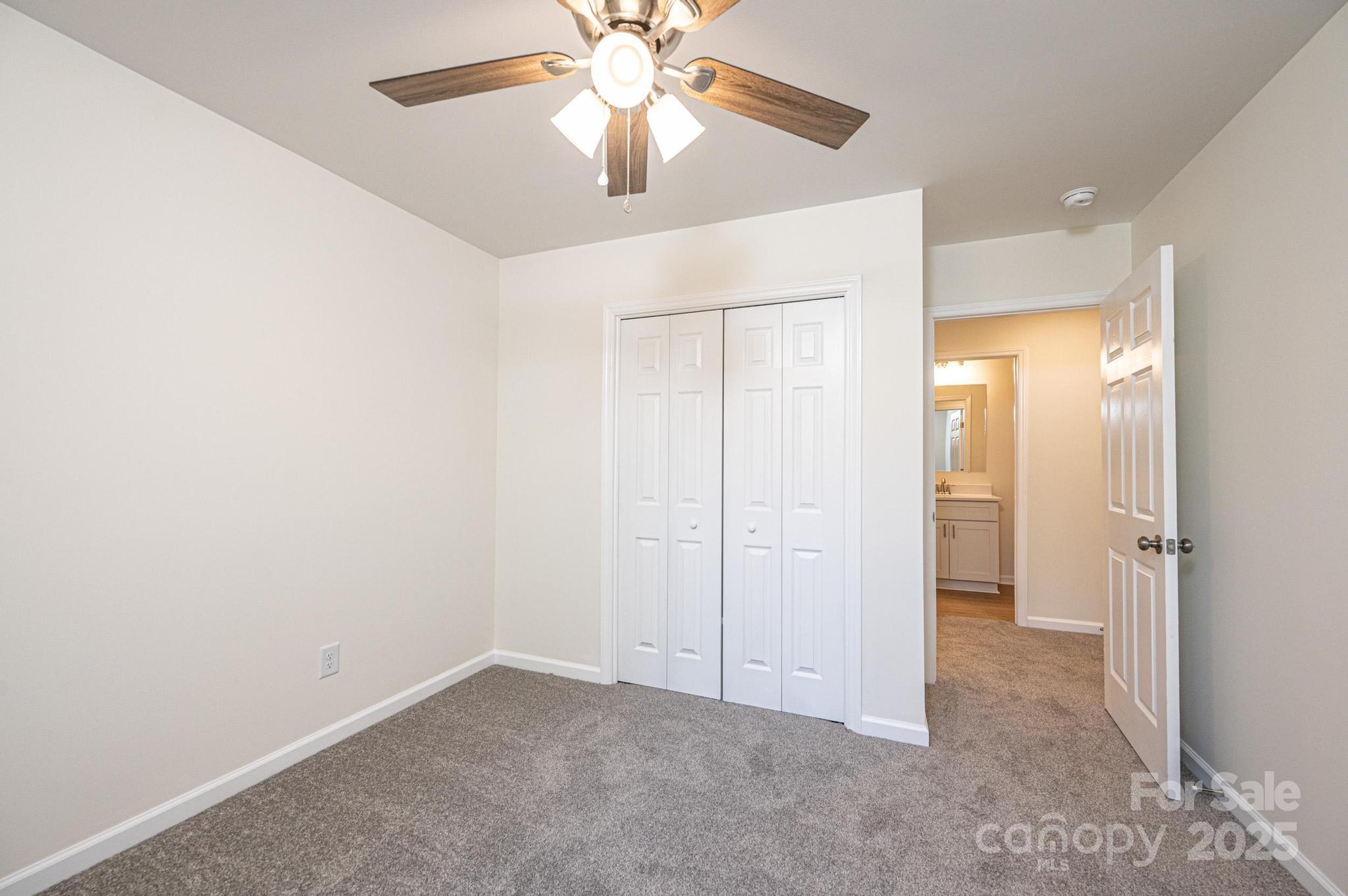 1449 4th Street Southwest Hickory, NC 28602 - Photo 11 of 19 an empty room with closet and a chandelier fan