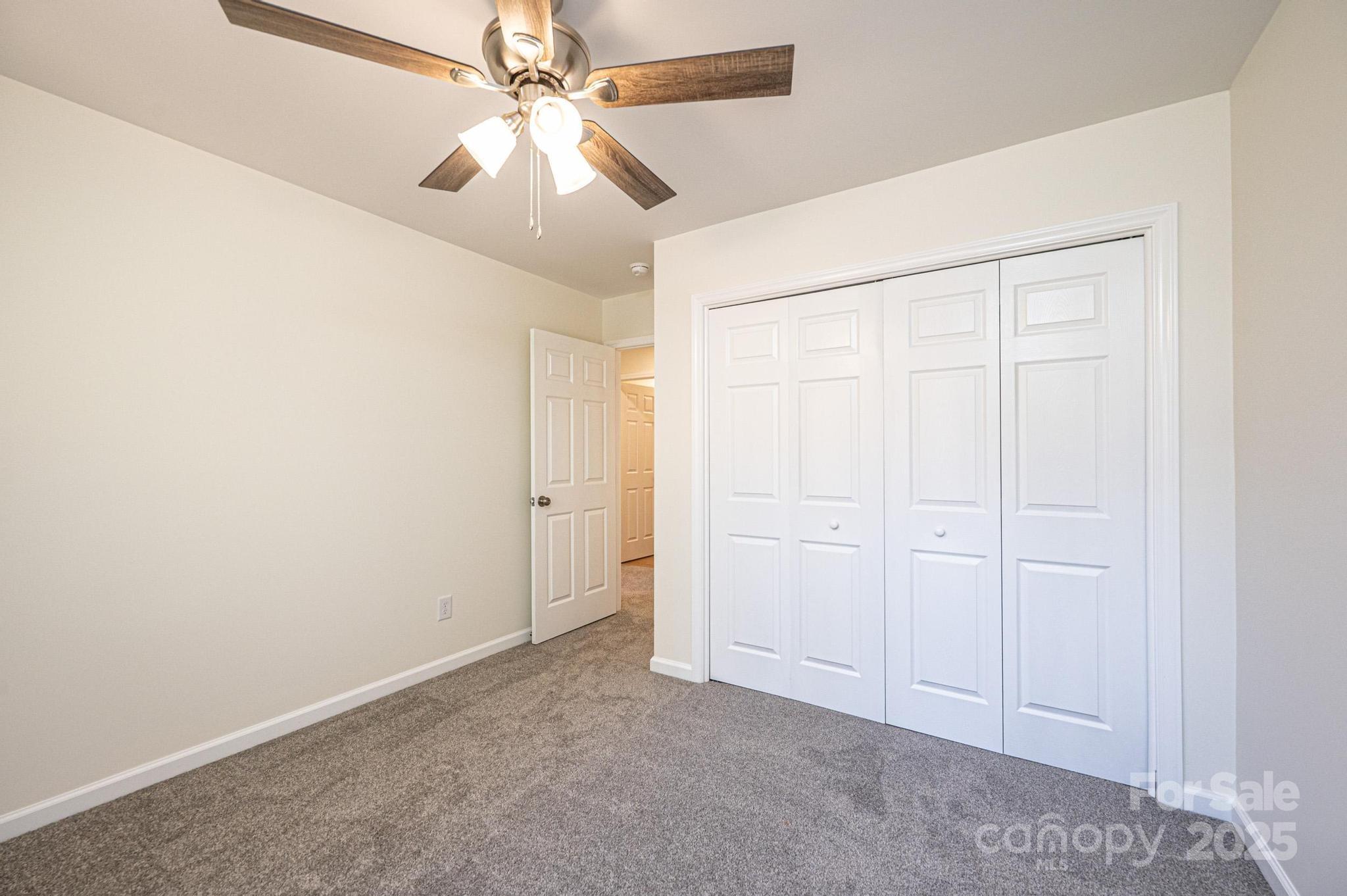 1449 4th Street Southwest Hickory, NC 28602 - Photo 12 of 19 an empty room with closet and a ceiling fan