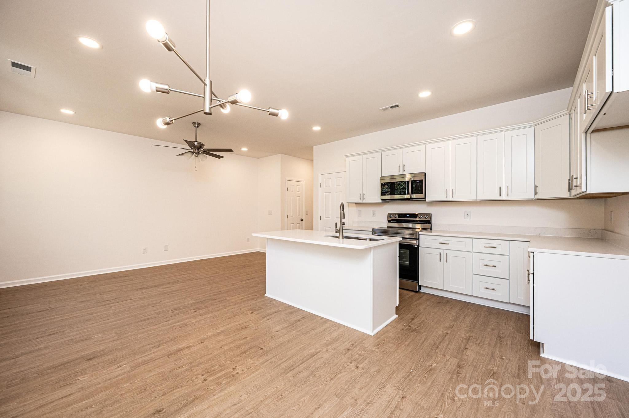 1449 4th Street Southwest Hickory, NC 28602 - Photo 4 of 19 a kitchen with granite countertop a stove cabinets and wooden floor