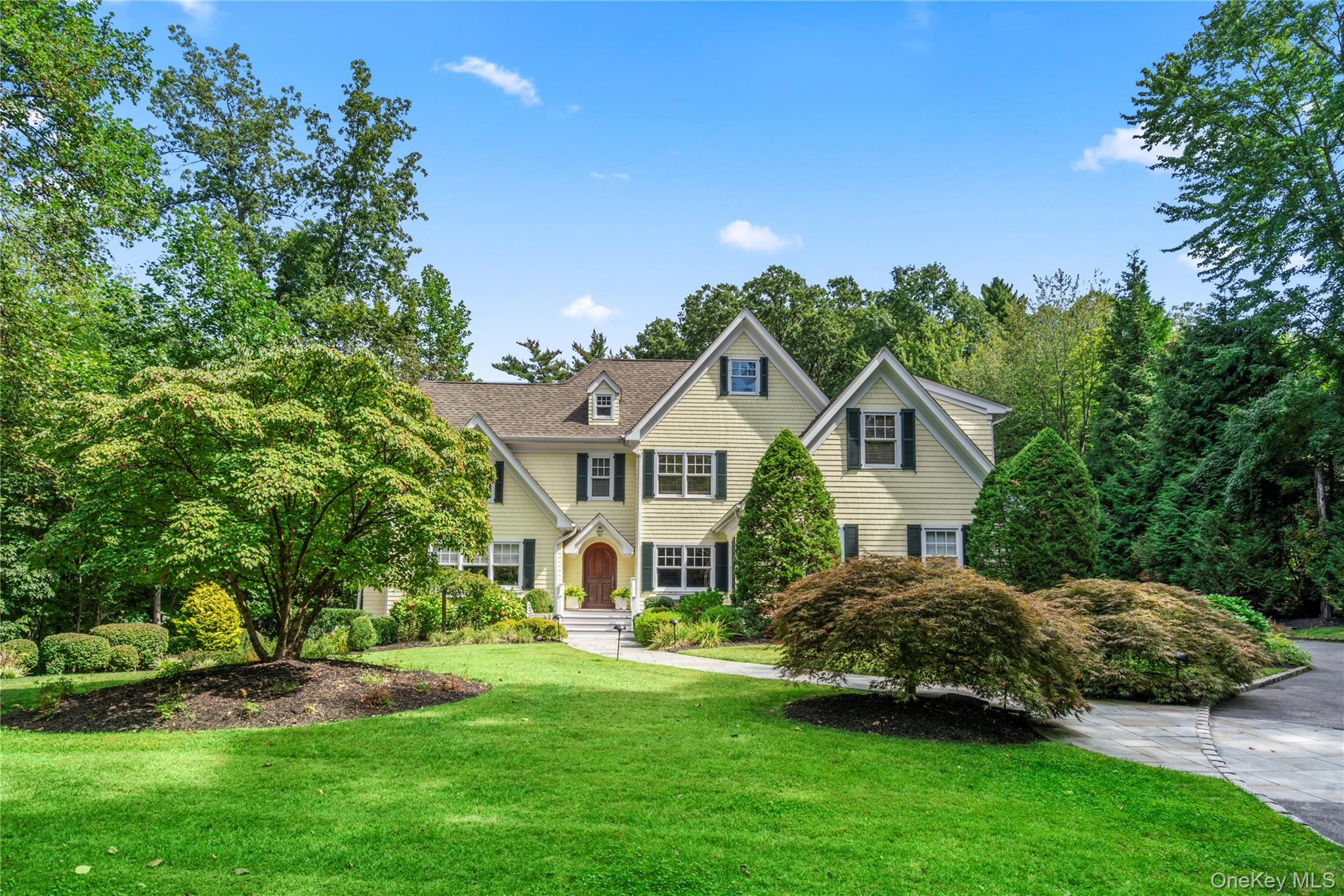 a front view of a house with a garden and plants