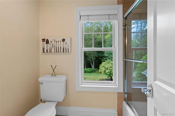 a bathroom with a toilet a sink and a window