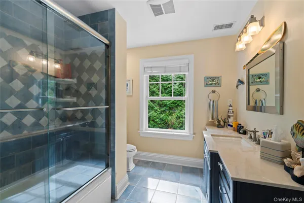 a bathroom with a granite countertop sink a toilet and shower