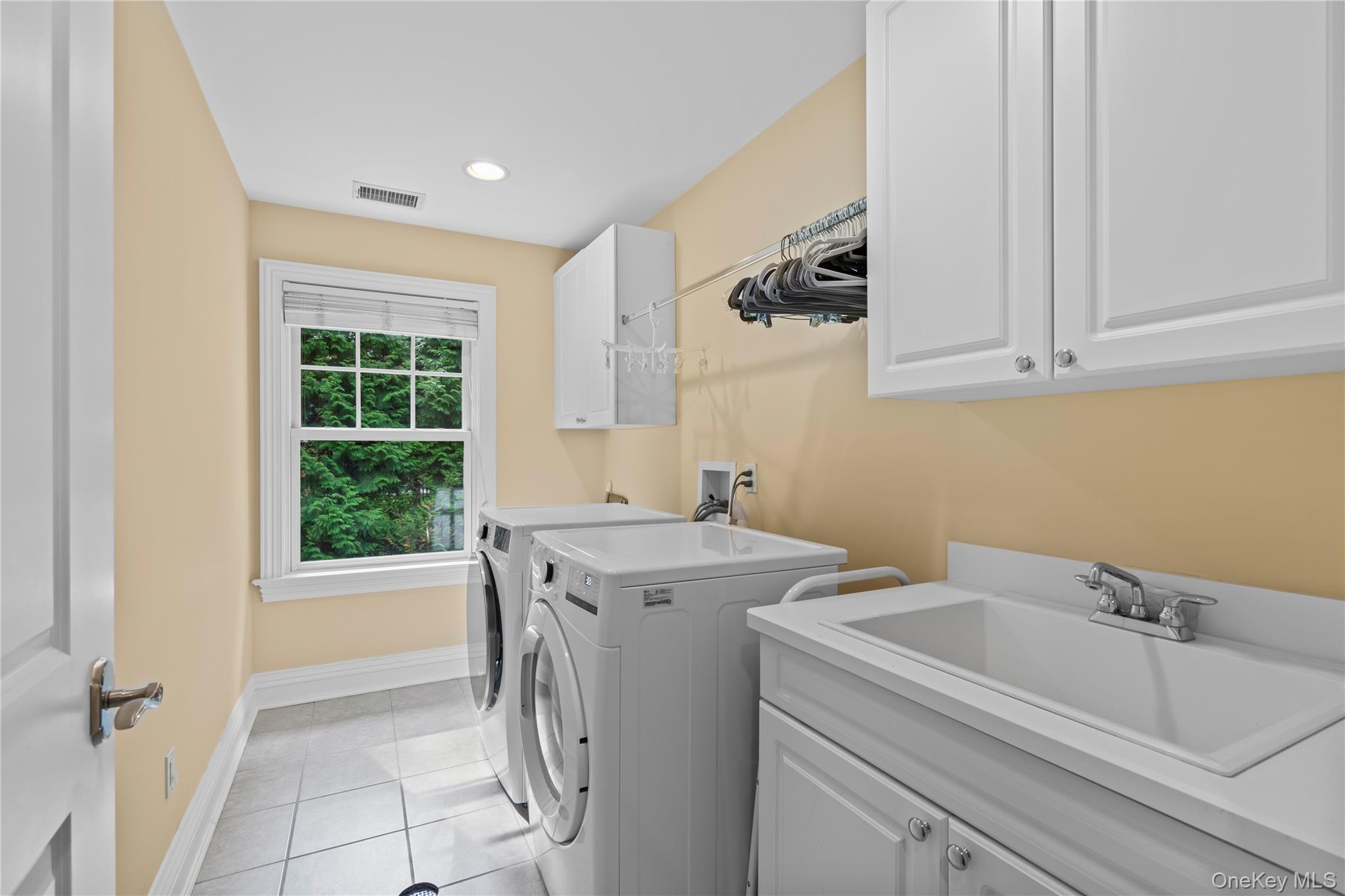 12 Parish Drive Locust Valley, NY 11560 - Photo 36 of 49 a view of a bathroom with a sink and washing machine