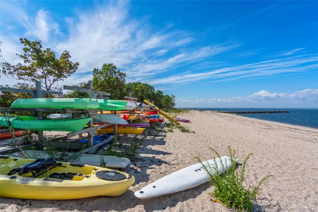a view of a dining room and livingroom with furniture wooden floor a rug a painting and a chandelier