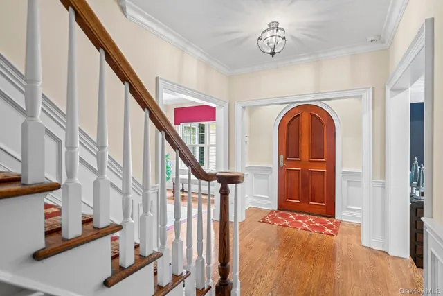 a dining room with wooden floor a chandelier a wooden table and chairs