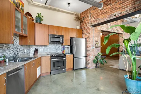 a kitchen with stainless steel appliances granite countertop a refrigerator a sink a stove and dishwasher