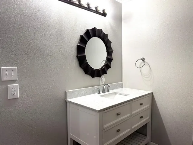a bathroom with a sink mirror and vanity
