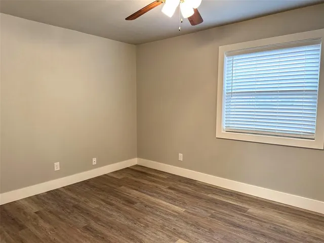 a view of a room with wooden floor and a window