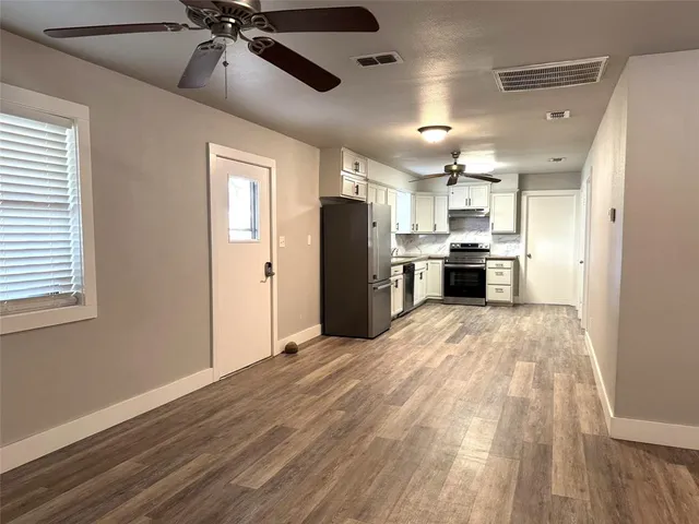 a view of a kitchen with a sink and a refrigerator