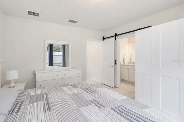 a spacious bedroom with a bed and a mirror