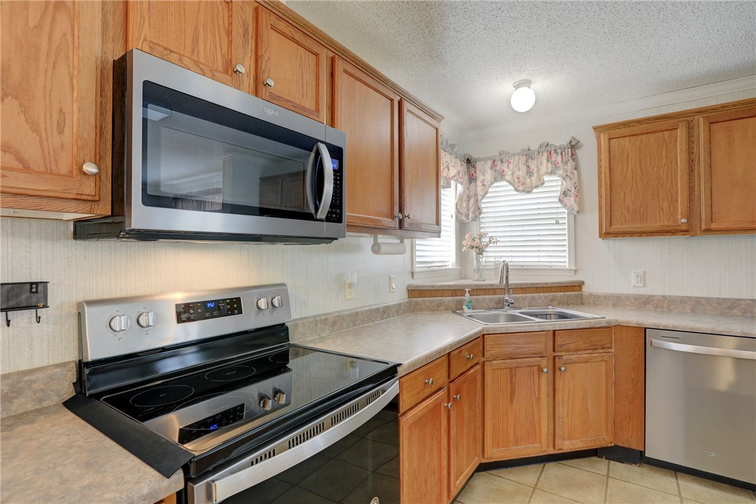 9755 61st Terrace Sebastian, FL 32958 - Photo 15 of 35 a kitchen with stainless steel appliances a stove microwave and sink