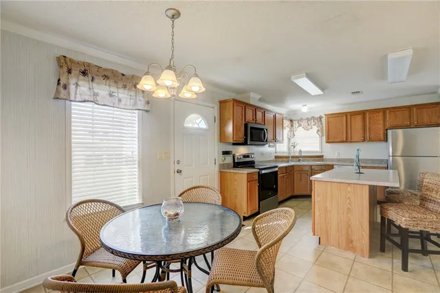 a kitchen with sink refrigerator dining table and chairs