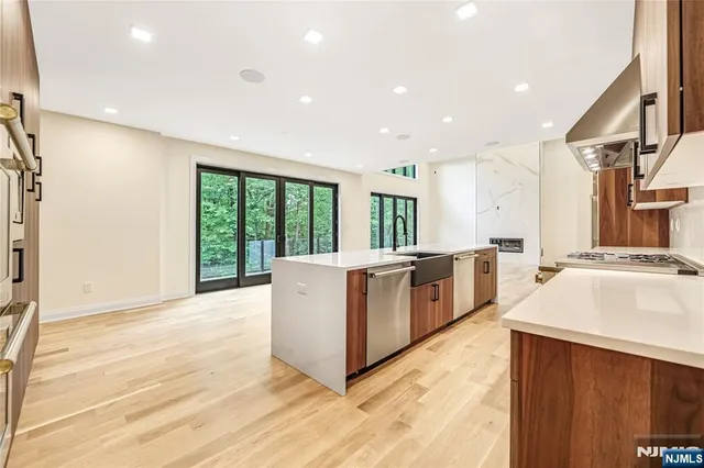 a kitchen with stainless steel appliances granite countertop a sink a stove and a refrigerator