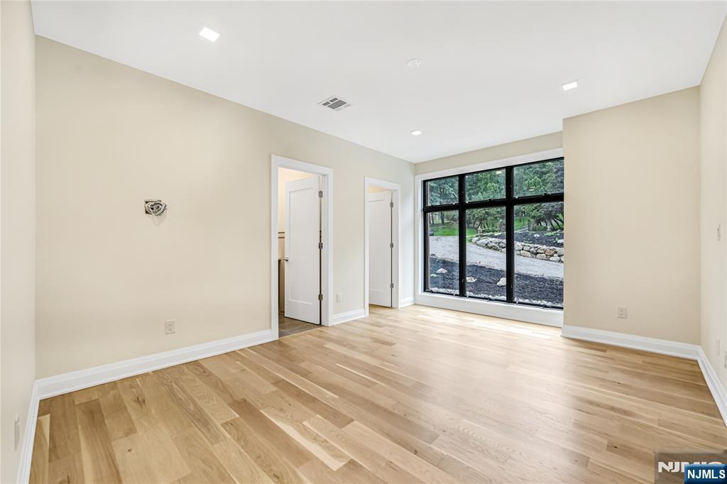 10 Big Ramapo Road Saddle River, NJ 07458 - Photo 15 of 44 a view of an empty room with wooden floor and a window