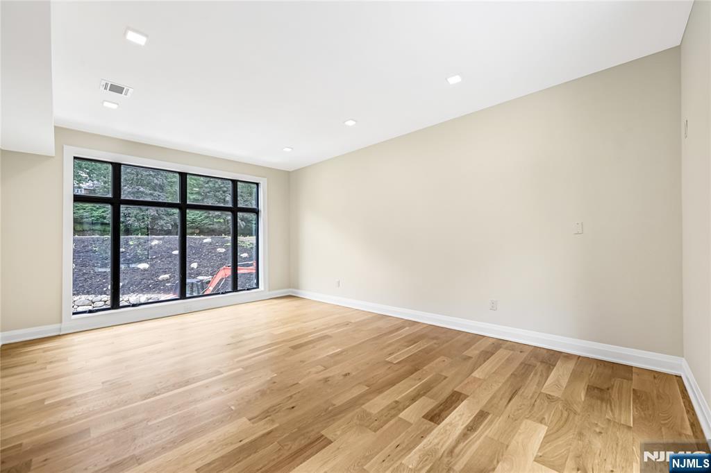 10 Big Ramapo Road Saddle River, NJ 07458 - Photo 16 of 44 a view of an empty room with wooden floor and a window
