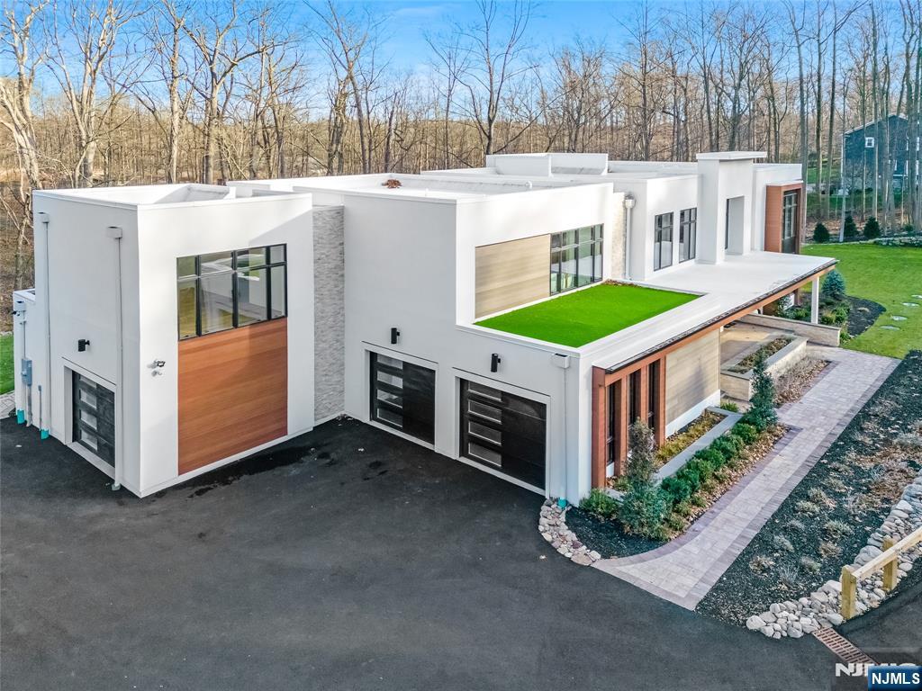 10 Big Ramapo Road Saddle River, NJ 07458 - Photo 2 of 44 a view of a white house with a big yard and large trees