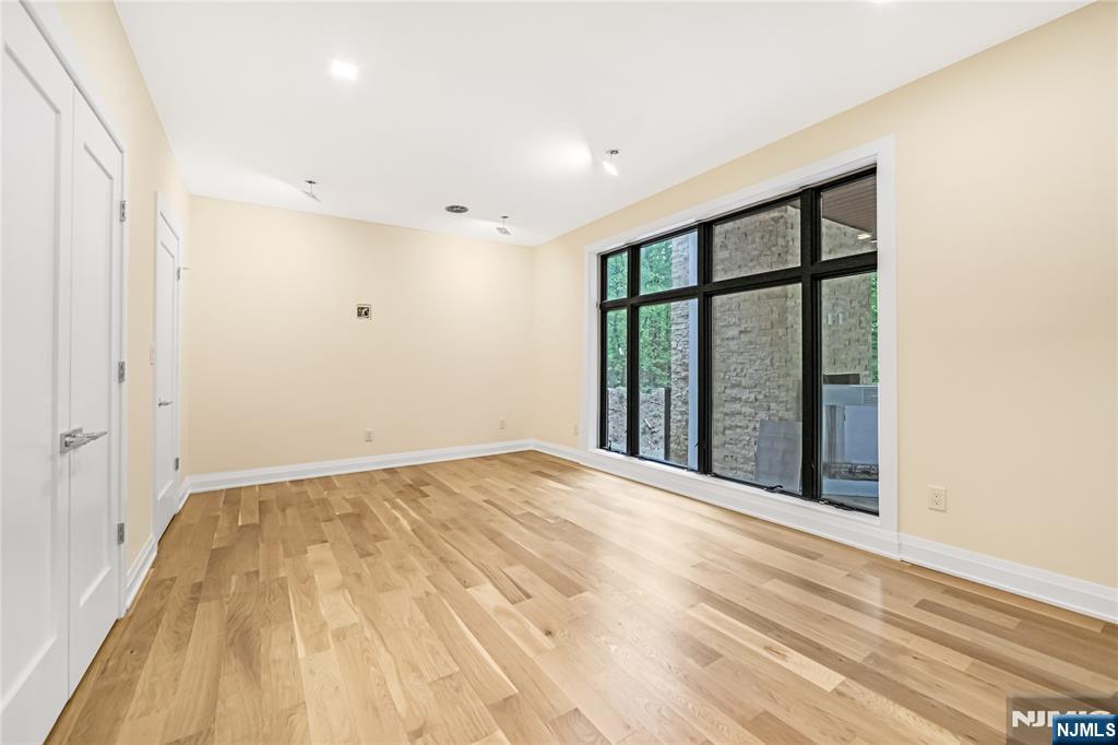 10 Big Ramapo Road Saddle River, NJ 07458 - Photo 21 of 44 a view of an empty room with wooden floor and a window