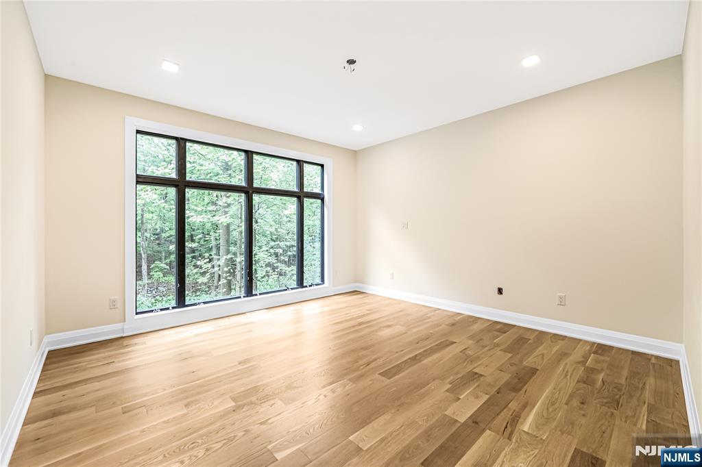 10 Big Ramapo Road Saddle River, NJ 07458 - Photo 22 of 44 a view of an empty room with wooden floor and a window