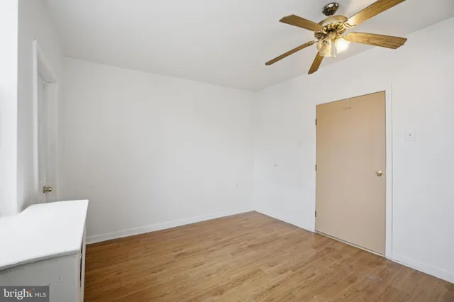 an empty room with ceiling fan and window