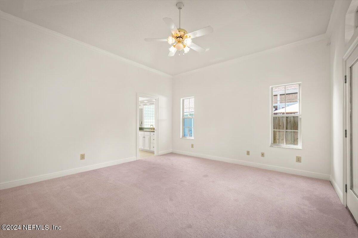 10967 Heathfield Road Jacksonville, FL 32225 - Photo 31 of 39 an empty room with a chandelier fan and windows