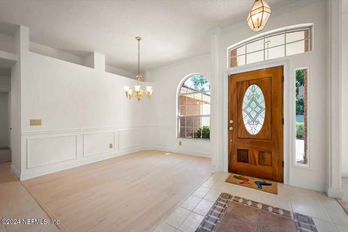 10967 Heathfield Road Jacksonville, FL 32225 - Photo 5 of 39 a view of a hallway with entryway wooden floor and a chandelier