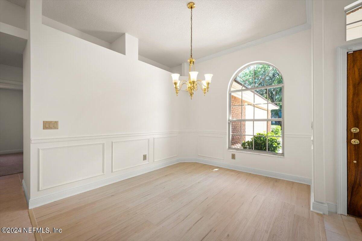 10967 Heathfield Road Jacksonville, FL 32225 - Photo 8 of 39 an empty room with wooden floor fan and windows