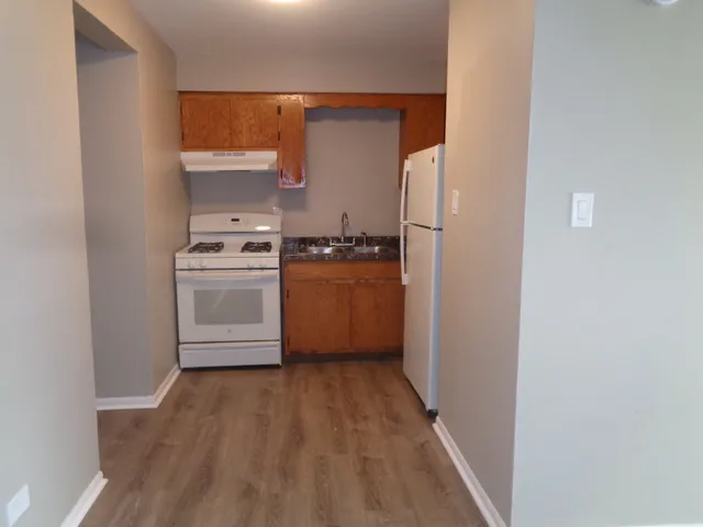 a kitchen with cabinets wooden floor and stainless steel appliances