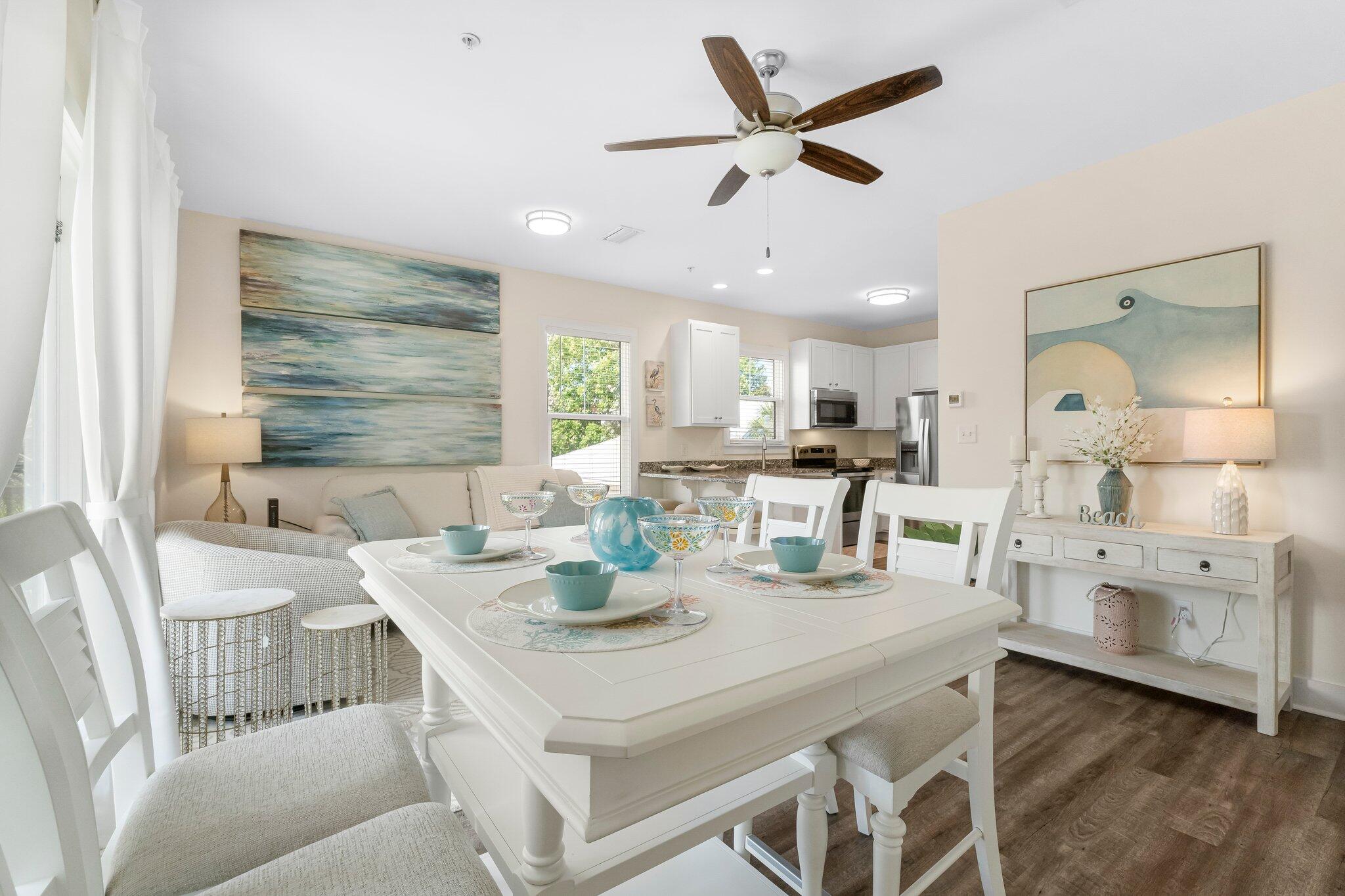 3958 West County Highway 30A, Unit 124 Santa Rosa Beach, FL 32459 - Photo 13 of 51 a kitchen with a dining table chairs and white cabinets