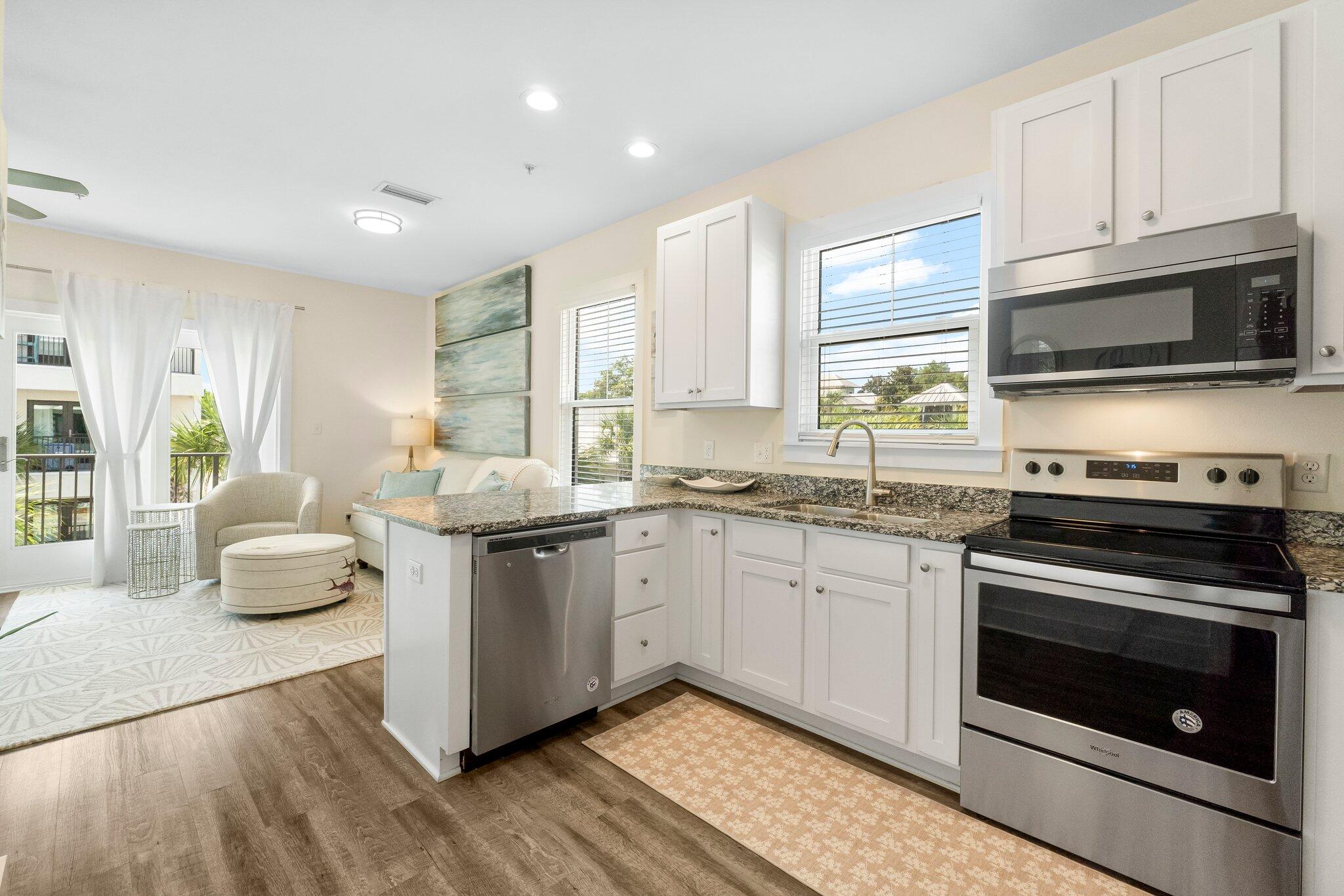 3958 West County Highway 30A, Unit 124 Santa Rosa Beach, FL 32459 - Photo 14 of 51 a kitchen with stainless steel appliances granite countertop a stove a sink and a microwave