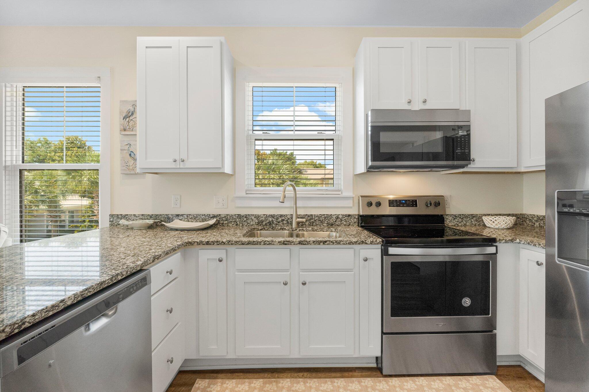 3958 West County Highway 30A, Unit 124 Santa Rosa Beach, FL 32459 - Photo 15 of 51 a kitchen with granite countertop a stove a sink and a microwave