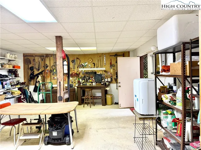 a view of a white house with a yard and table and chairs under an umbrella