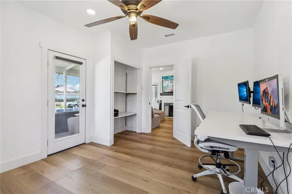 a view of a workspace with furniture and wooden floor