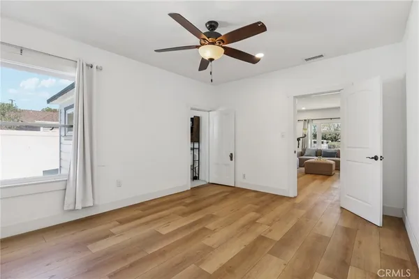 a view of a livingroom with wooden floor and a ceiling fan