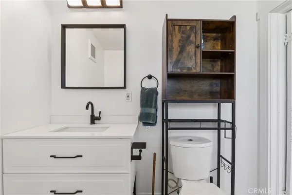 a bathroom with a toilet sink and mirror