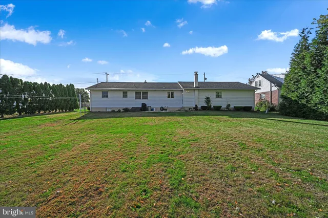 a front view of a house with a garden and swimming pool