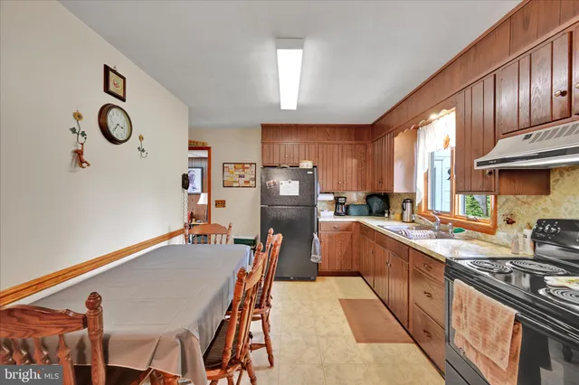 a kitchen with granite countertop a refrigerator stove top oven a sink and dishwasher